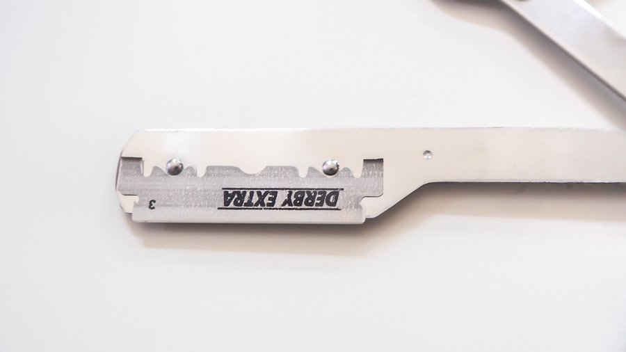 Standard Rasierklinge 43mm in einem Klingenhalter für ein Wechselklingenmesser mit flexibel beweglichen Klingenarmen.