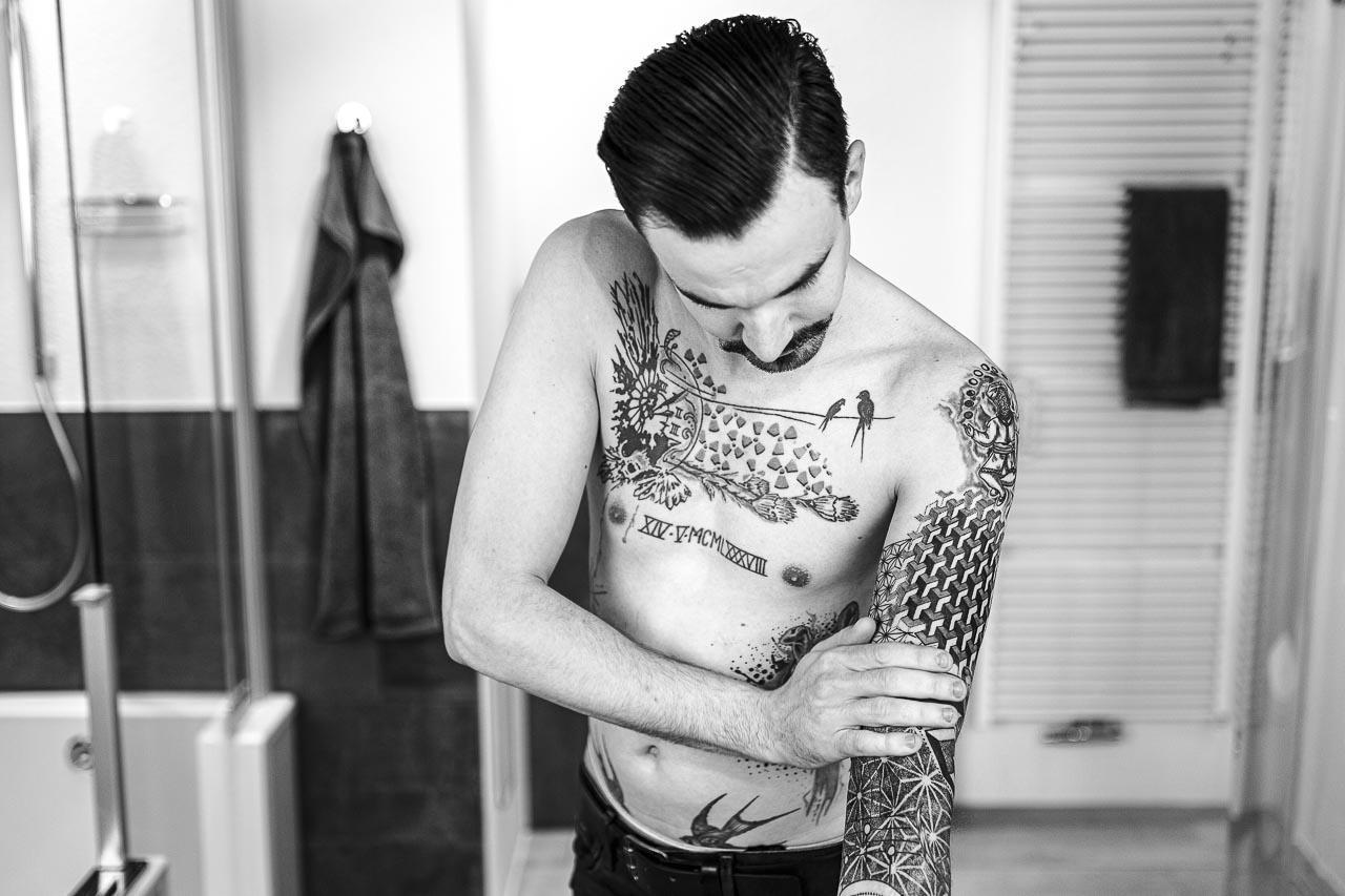 Ein Mann pflegt sein frisch gestochenes Tattoo.